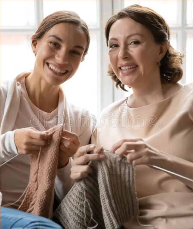 two women smiling & knitting